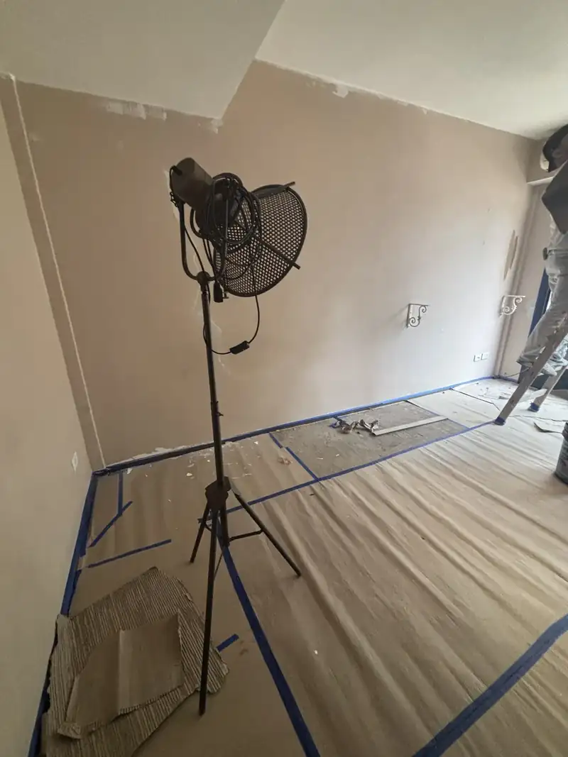 Ambiente con el piso cubierto con cartón y cinta de pintor antes de empezar a pintar