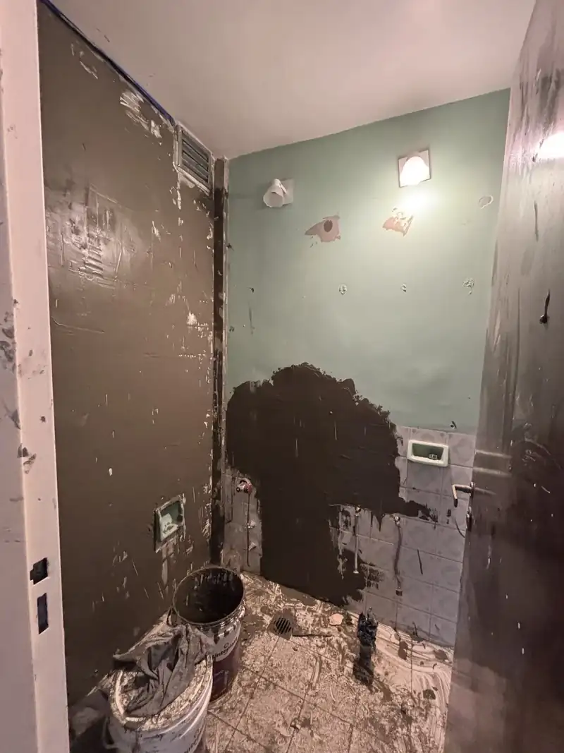 Baño en obra con membrana asfáltica aplicada en la pared antes de revestir