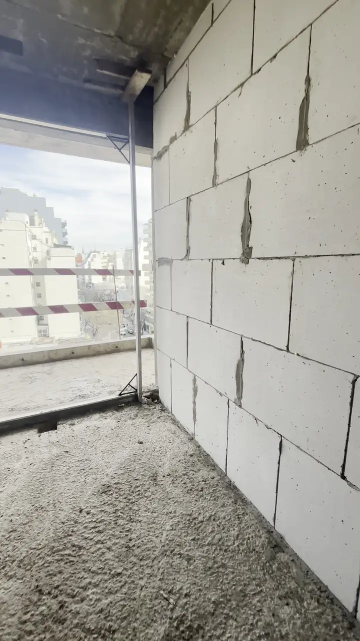 Balcón y paredes de bloques en un piso de un edificio en obra gris
