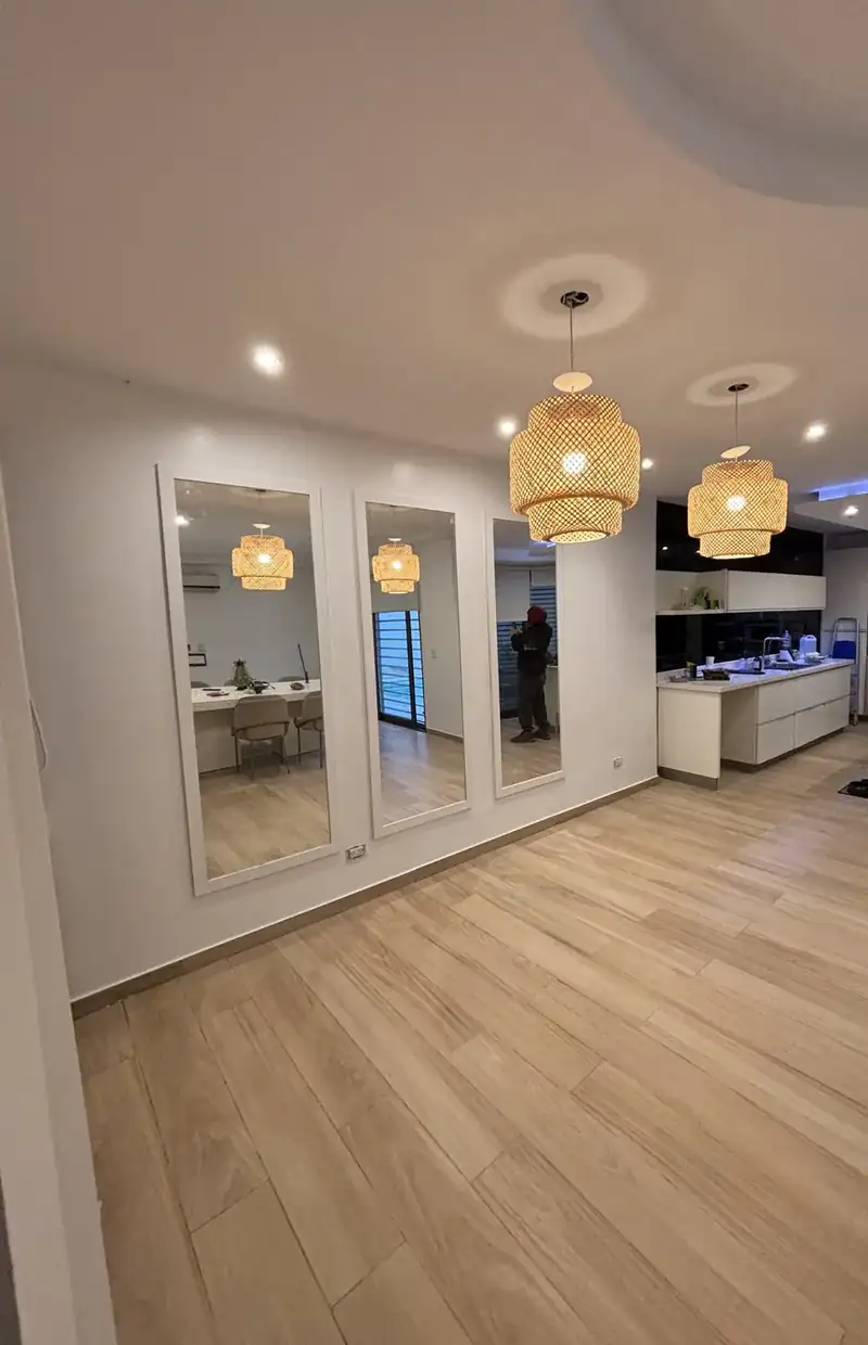 Living y cocina integrados terminados, con luces LED, lámparas colgantes y piso símil madera