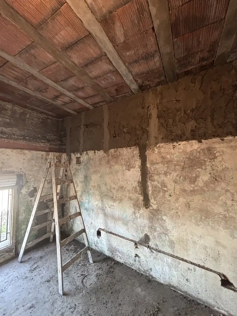 Pared con manchas de humedad y revoque picado, antes de la reparación
